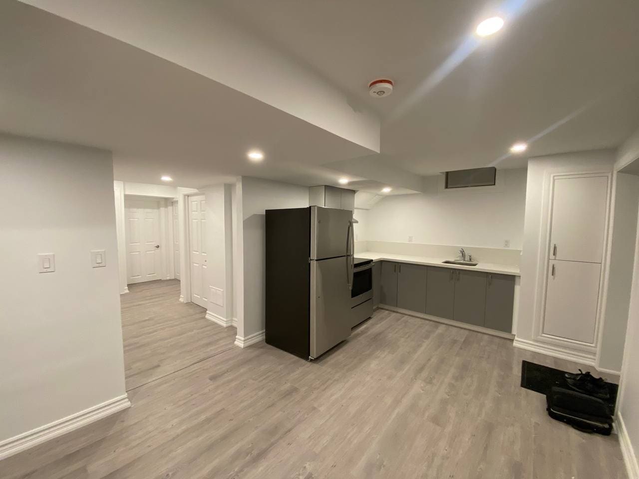 Finished basement with a compact kitchenette, vinyl plank flooring and recessed lighting