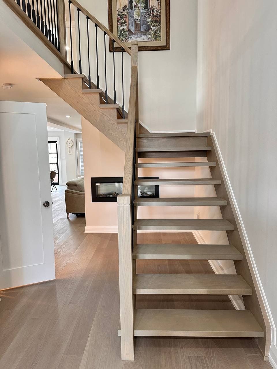Custom built interior with an open riser staircase and a two sided fireplace